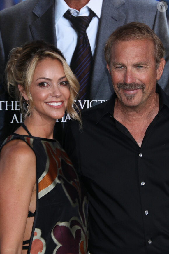 Kevin Costner et sa femme Christine Baumgartner lors de la première du film "Draft Day" au théâtre Regency Village à Westwood, le 7 avril 2014. 