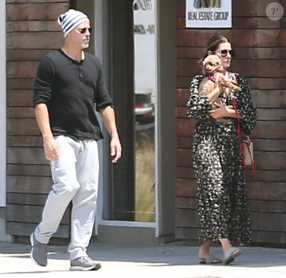 Sandra Bullock se promène avec son compagnon Bryan Randall et son petit chien à la sortie d'une animalerie à Los Angeles, le 8 juillet 2019.