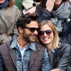 Maxim Nucci (Yodelice) et sa compagne Isabelle Ithurburu dans les tribunes des Internationaux de France de tennis de Roland Garros à Paris, le 24 mai 2016.