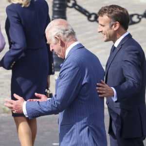 Le roi Charles III d'Angleterre et la reine consort Camilla Parker Bowles, le président français Emmanuel Macron et sa femme Brigitte Macron lors de la cérémonie du ravivage de la Flamme à l'Arc de Triomphe à Paris, le 20 septembre 2023. 