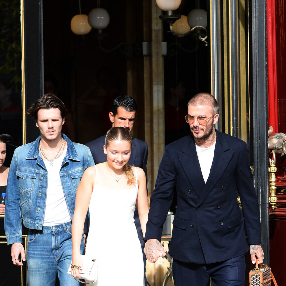 David Beckham et ses enfants, Harper et Cruz quittent l'hôtel La Réserve à Paris, pour assister au défilé de Victoria Beckham lors de la Fashion Week, le 29 septembre 2023. Davd Beckham a succombé à la mode des claquettes portées avec des chaussettes.