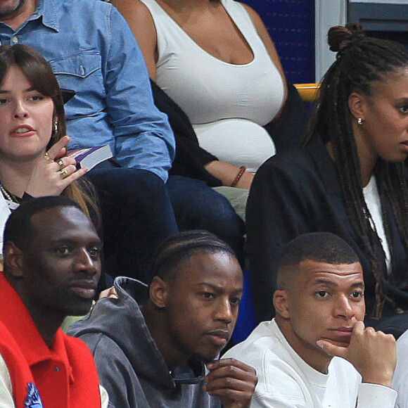 Un sport qui sied bien à la taille de Tidiane, un géant
Omar Sy, Brice Tchaga et Kylian Mbappé assistent au match de basket entre les metropolitans 92 vs paris basketball au gymnase Marcel-Cerdan de Levallois le 16 mai 2023. Les Mets92 se sont imposés mardi soir face à Paris Basketball lors de la dernière journée de la saison régulière.
