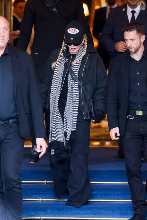 Madonna entourée de ses gardes du corps à la sortie de l'hôtel Ritz à Paris, France, le 13 novembre 2023.
