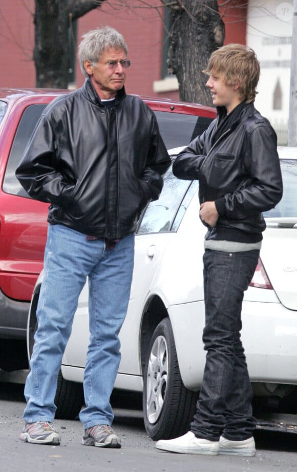 EXCLUSIVE. US actor Harrison Ford and his son Malcom are like father like son, wearing black leather jackets. They are outside Bar Piti where they had lunch. Malcom lits a cigarrette behind his famous father's back as they walked in search of a cab in New York, NY, USA, on March 15, 2006. Photo by Hector Vallenilla/ABACAPRESS.COM 