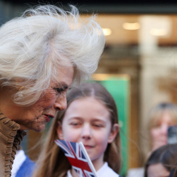 Camilla Parker Bowles, reine consort d'Angleterre, à la rencontre des habitants de Swindon, en marge de sa visite de la bijouterie familiale Deacon & Son, qui célèbre ses 175 ans d'activité, le 22 janvier 2024. Les enfants tiennent dans leurs mains des cartes de prompt rétablissement à l'attention du roi, opéré de la prostate cette semaine. 