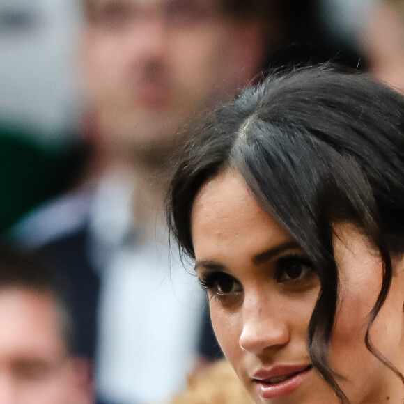 Photo sur laquelle elle pose avec Harry en arrière quand Archie occupe le premier. Le visage du prince Harry est flou, celui de Meghan très retouché
Catherine (Kate) Middleton, duchesse de Cambridge et Meghan Markle, duchesse de Sussex assistent au match de tennis Nadal contre Djokovic lors du tournoi de Wimbledon "The Championships" le 14 juillet 2018