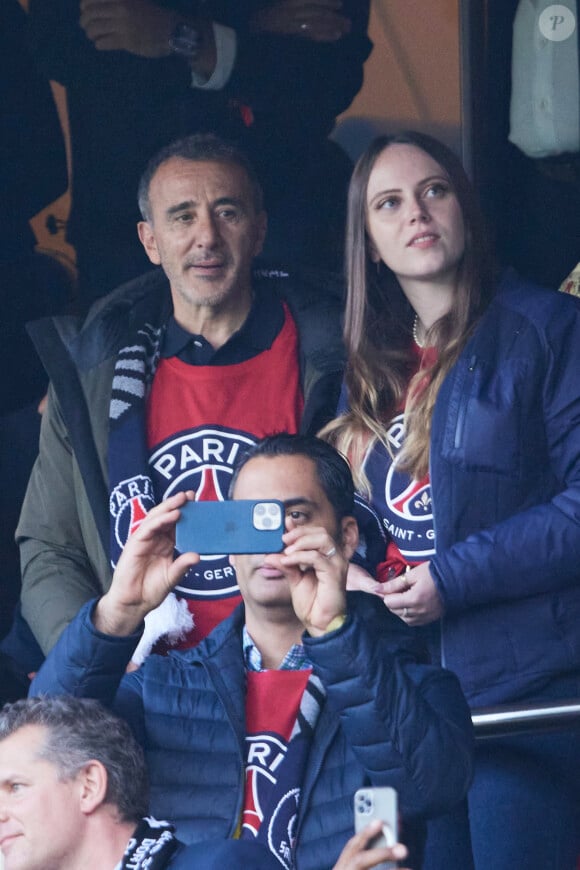 Elie Semoun et une amie - Célébrités dans les tribunes de la demi-finale retour de Ligue des champions entre le PSG face au Borussia Dortmund (0-1) au Parc des Princes à Paris le 7 mai 2024. © Cyril Moreau/Bestimage