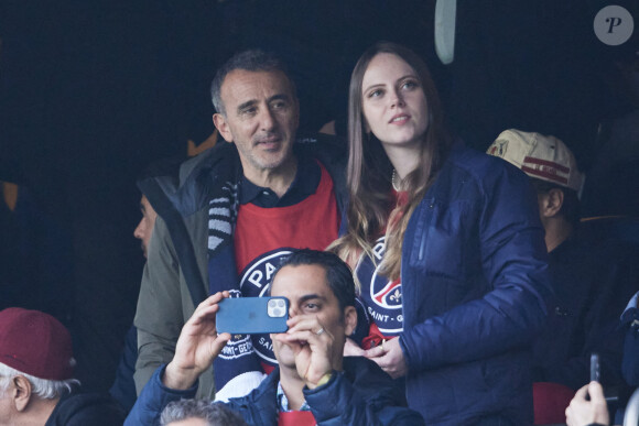 Elie Semoun et une amie - Célébrités dans les tribunes de la demi-finale retour de Ligue des champions entre le PSG face au Borussia Dortmund (0-1) au Parc des Princes à Paris le 7 mai 2024. © Cyril Moreau/Bestimage