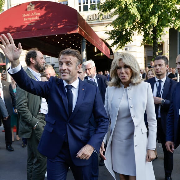 Le président français, Emmanuel Macron et la première dame, Brigitte Macron accueilis par le Bourgmestre gouverneur de Berlin à la Porte de Brandebourg, lors une visite d'Etat de trois jours en Allemagne, le 26 mai 2024. © Ludovic Marin/Pool/Bestimage  Le président français, Emmanuel Macron et la première dame, Brigitte Macron accueilis par le Bourgmestre gouverneur de Berlin à la Porte de Brandebourg, lors une visite d'Etat de trois jours en Allemagne, le 26 mai 2024. © Ludovic Marin/Pool/Bestimage  French President Emmanuel Macron (L) and his wife Brigitte Macron greet spectators in front of Berlin's Adlon Hotel after walking through the landmark Brandenburg Gate in Berlin on May 26, 2024, as part of the French president's state visit to Germany. / SOLELY FOR BESTIMAGE 