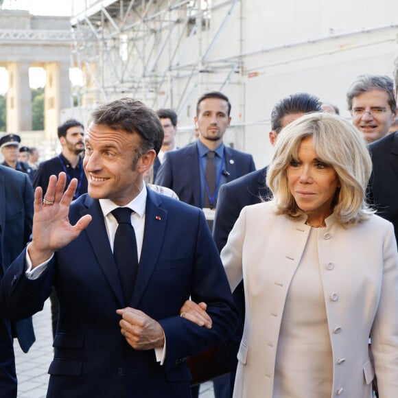 Si elle a opté pour une tenue classique tout en laissant ses cheveux détachés la journée, l'heureuse maman de trois enfants a sorti le grand jeur le soir... 
Le président français, Emmanuel Macron et la première dame, Brigitte Macron accueilis par le Bourgmestre gouverneur de Berlin à la Porte de Brandebourg, lors une visite d'Etat de trois jours en Allemagne, le 26 mai 2024. © Ludovic Marin/Pool/Bestimage 