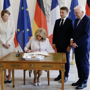 Emmanuel Macron et Brigitte Macron accueilis par Franck-Walter Steinmeier, président de la république fédérale d'Allemagne et madame Elke Budenbender au château de Bellevue, suivie d'une conférence de presse lors une visite d'Etat de trois jours en Allemagne, le 26 mai 2024. © Ludovic Marin/Pool/Bestimage  The French president's wife Brigitte Macron signs the guestbook as German President Frank-Walter Steinmeier (R) and his wife Elke Buedenbender (L) and French President Emmanuel Macron look on at Bellevue presidential palace in Berlin, Germany on May 26, 2024. The French president pays a three-day state visit to Germany until May 28. 