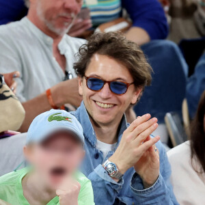 Et le jeune garçon semble aussi fan de tennis que ses parents ! 
Le chanteur Raphael et son fils Aliocha dans les tribunes pour le premier tour des Internationaux de France de tennis de Roland Garros 2024 opposant R.Nadal (Rafa) à A.Zverev, à Paris, France, le 27 mai 2024. © Jacovides-Moreau/Bestimage