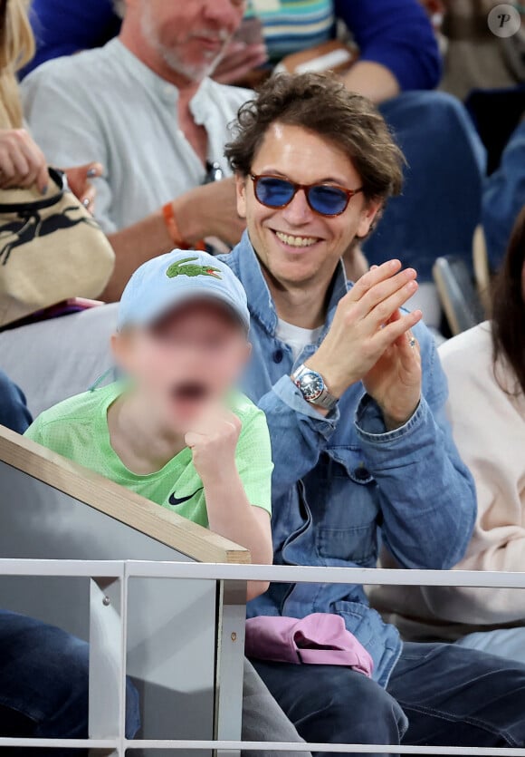 Et le jeune garçon semble aussi fan de tennis que ses parents ! 
Le chanteur Raphael et son fils Aliocha dans les tribunes pour le premier tour des Internationaux de France de tennis de Roland Garros 2024 opposant R.Nadal (Rafa) à A.Zverev, à Paris, France, le 27 mai 2024. © Jacovides-Moreau/Bestimage