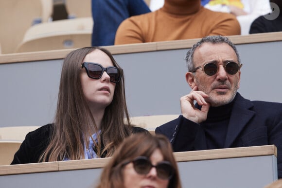 Elie Semoun et sa compagne dans les tribunes au même moment dans les tribunes des Internationaux de France de tennis de Roland Garros 2024 à Paris, France, le 2 juin 2024. © Jacovides-Moreau/Bestimage 