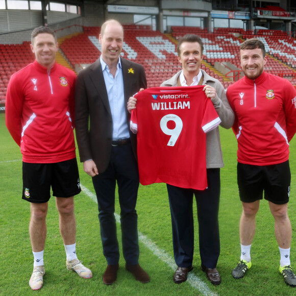 Heureusement, il adore le football. 
Le Prince de Galles visite l'AFC de Wrexham et rencontre le président du club, Rob McElhenney, le 1er mars 2024. 