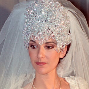 Sur la tête de la diva, une tiare composée de 2000 cristaux autrichiens retient son voile. La traine, d'une longueur exceptionnelle de 6 mètres, était tenue par ses huit soeurs, toutes vêtues de la même robe couleur crème et d'une cape à capuchon. 
Céline Dion lors de son mariage avec René Angelil le 17 décembre 1994