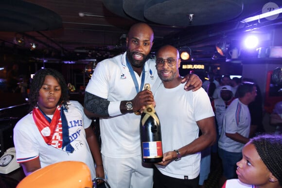 Exclusif - Teddy Riner avec son fils Eden et Franck Nema, le directeur du groupe (Les bistrots Pas Parisiens) - Teddy Riner fête son titre de champion Olympique de judo +100KG au restaurant "Podium" du groupe (Les bistrots Pas Parisiens) à Paris le 2 aout 2024. © Rachid Bellak/Bestimage