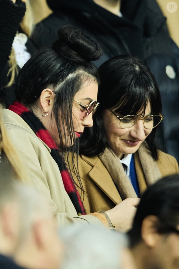 Hoshi et sa compagne Gia Martinelli dans les tribunes du match aller des 8èmes de finale de la ligue des champions entre le PSG et le Bayern Munich au Parc des Princes à Paris le 14 février 2023. 