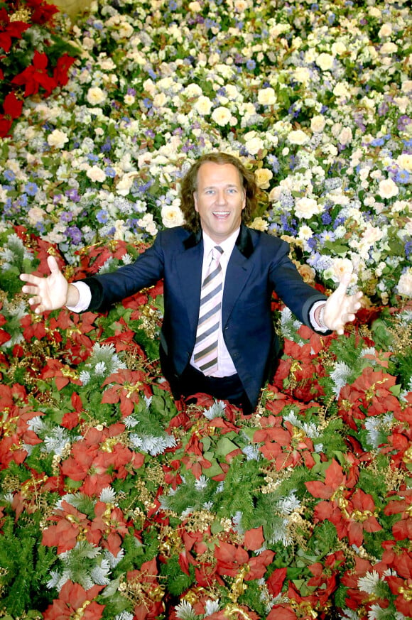 Le violoniste vedette néerlandais André Rieu sourit au milieu d'une mer de fleurs artificielles à Maastricht, aux Pays-Bas, le 2 novembre 2005. Scheidemann/DPA/ABACAPRESS.COM