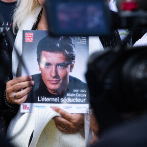 De la part de celui qui pleure depuis plus d'un mois déjà la mort de son père
Les fans rendent hommage à Alain Delon devant la grille de sa propriété à Douchy-Montcorbon pendant ses obsèques le 24 août 2024. © Baptiste Autissier / Panoramic / Bestimage 