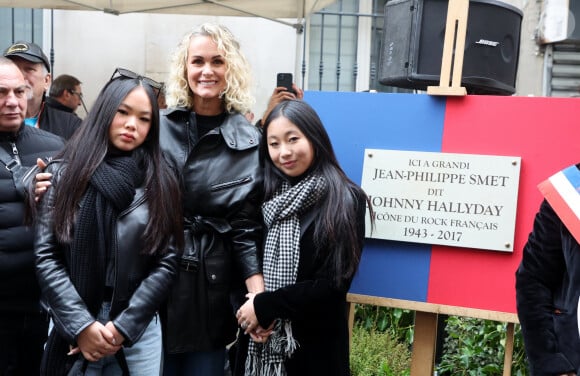 Laeticia Hallyday, ses filles Joy et Jade lors de l'inauguration d'une plaque commémorative en hommage à Johnny Hallyday devant l'immeuble où le chanteur français a grandi dans le 9ème arrondissement de Paris, France, le 22 décembre 2023. Décédé en 2017, Johnny Hallyday fut pendant un demi-siècle l'incarnation du rock à la française. D'origine belge et né sous le nom de Jean-Philippe Smet, il naquit et passa une très grande partie de sa vie à Paris. Fière de cet héritage musical qu'il lui laissa, la Ville de Paris avait entrepris un premier hommage à l'artiste en donnant le nom de Johnny Hallyday à l'esplanade situé devant la salle de spectacle qu'il avait tant fait vibrer par le passé. Dans la continuité de ce premier hommage, la ville de Paris a souhaité à nouveau honorer la mémoire de ce natif de la capitale et une plaque commémorative est dévoilée devant l'immeuble dans lequel il grandit au 13 rue de la Tour des Dames dans le 9ème arrondissement. © Dominique Jacovides/Bestimage