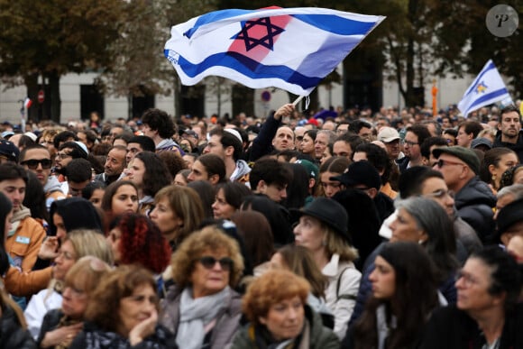 Des personnes brandissent des drapeaux israéliens lors d'une marche en hommage aux victimes de l'attaque du 7 octobre contre Israël par le Hamas, à Paris, le 6 octobre 2024. © Stéphane Lemouton / Bestimage 