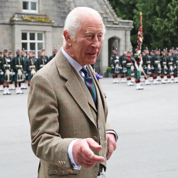 Le roi Charles III d'Angleterre, accueilli par des soldats de la compagnie Balaklava, 5e bataillon du Royal Regiment of Scotland devant le château de Balmoral (Ecosse), où le souverain débute ses vacances d'été, le 19 août 2024. 