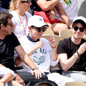 Patrick Bruel et ses fils Léon et Oscar dans les tribunes des Internationaux de France de tennis de Roland Garros 2024 à Paris, France, le 4 juin 2024. © Jacovides-Moreau/Bestimage 