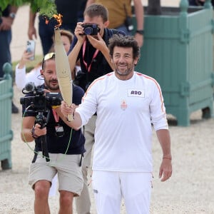 Le chanteur et acteur Patrick Bruel porteur de la flamme olympique des Jeux Olympiques de Paris 2024 (JO) au château de Versailles dans les Yvelines, France, le 23 juillet 2024. © Dominique Jacovides/Bestimage 