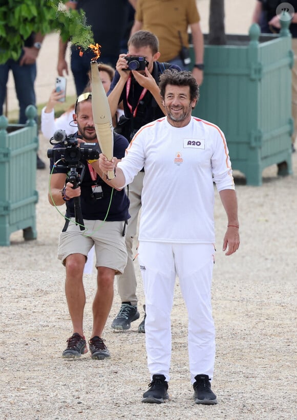 Le chanteur et acteur Patrick Bruel porteur de la flamme olympique des Jeux Olympiques de Paris 2024 (JO) au château de Versailles dans les Yvelines, France, le 23 juillet 2024. © Dominique Jacovides/Bestimage 