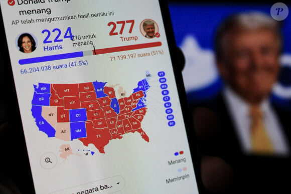 6 novembre 2024, Bandung, Java Ouest, Indonésie : Un homme tient un smartphone montrant le site web des résultats des élections alors qu'elle attend le décompte des votes de l'élection américaine de 2024 entre Donald Trump et Kamala Harris à Bandung, en Indonésie. Les électeurs américains se sont rendus aux urnes pour désigner le 47e président des États-Unis. Les sondages réalisés au cours des dernières semaines ont révélé une course serrée entre la candidate démocrate à la présidence, la vice-présidente Kamala Harris, et le candidat républicain à la présidence, l'ancien président Donald Trump, pour succéder au président Joe Biden à la Maison Blanche. (Crédit photo : © Algi Febri Sugita/ZUMA Press Wire)