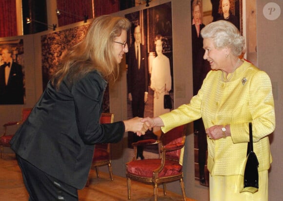 La reine Élisabeth II salue la photographe Annie Leibovitz lors d'une réception au palais de Buckingham pour les Américains au Royaume-Uni et avant la visite d'État de la reine aux États-Unis, à Londres, au Royaume-Uni, le 27 mars 2007.