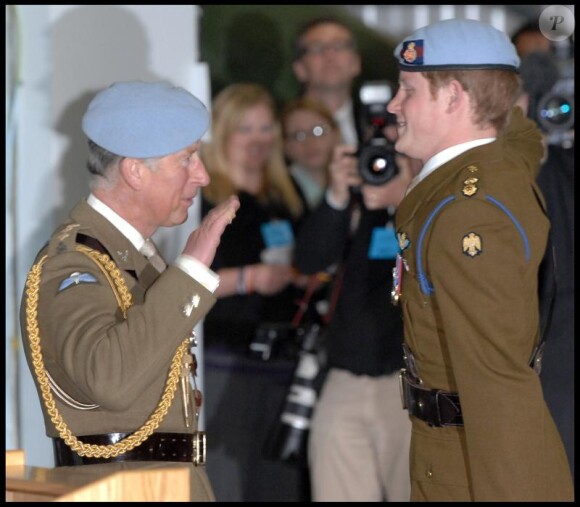 Le prince Charles décore son fils, le prince Harry, des insignes de l'armée de l'Air, lui qui est devenu pilote d'hélicoptère, le 7 mai 2010 dans le Hampshire