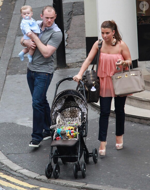 Wayne Rooney, son épouse Coleen et leur petit Kai sortent du restaurant San Carlo à Manchester le 31 mai 2010