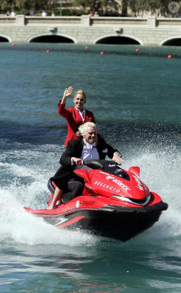 Richard Branson donne une conférence de presse aquatique, en compagnie d'une hôtesse de l'air de sa compagnie, à Las Vegas, le 16 juin 2010.