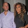 Melanie Brown et son mari Stephen Belafonte s'arrêtent devant leur hôtel afin d'admirer une cracheuse de feu, dimanche 10 octobre, à Londres.