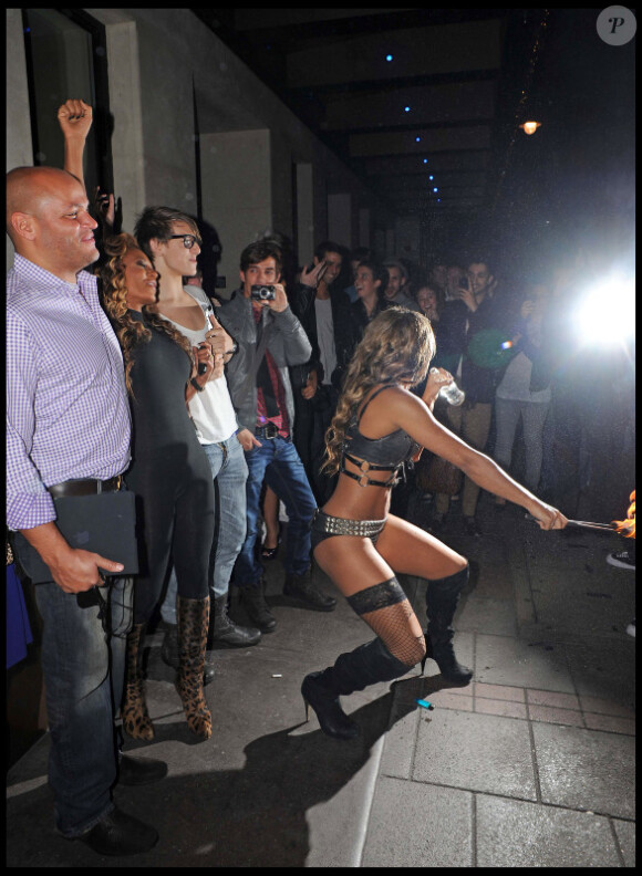 Melanie Brown et son mari Stephen Belafonte s'arrêtent devant leur hôtel afin d'admirer une cracheuse de feu, dimanche 10 octobre, à Londres.