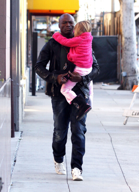Le chanteur Seal porte sa fille Leni dans ses bras, la petite s'est endormie, dans les rues de Los Angeles le 21 février 2011