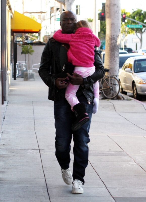 Le chanteur Seal porte sa fille Leni dans ses bras, la petite s'est endormie, dans les rues de Los Angeles le 21 février 2011