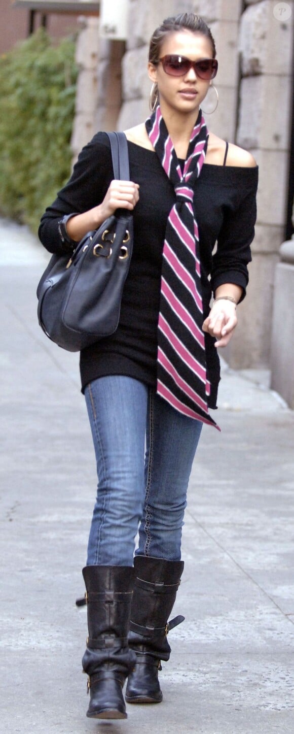 Jean, pull noir, grosses boots... Jessica Alba adore le look masculin et ça se voit ! Elle sait toutefois le féminiser avec un sac griffé, des créoles et une longue cravate rose. New York, 3 novembre 2005