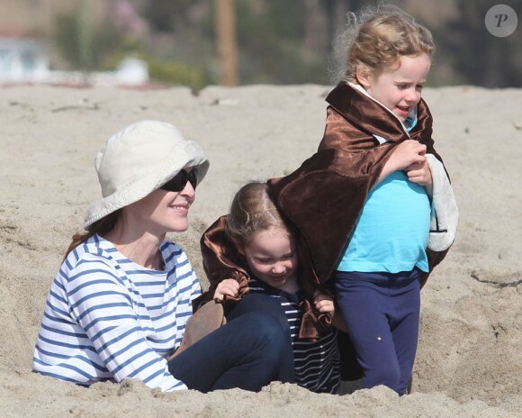 Marcia Cross et ses jumelles Eden s'amusent sur la plage en creusant un trou dans le sable ! Enveloppées dans leur serviette de plage, les jumelles passent du bon temps avec leur mère à Santa Monica, Los Angeles, le 22 avril 2011.