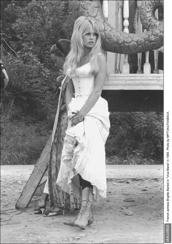L'actrice francaise, alors agée de 41 ans, porte une longue robe aux motifs brodés sur le tournage du film Viva Maria. Photo prise en 1965.