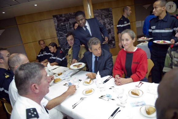 Nicolas Sarkozy en visite sur le Charles de Gaulle à Toulon le 12 août 2011. Le président y a reçu en cadeau de l'équipage deux layettes pour le bébé que porte son épouse Carla Bruni-Sarkozy.