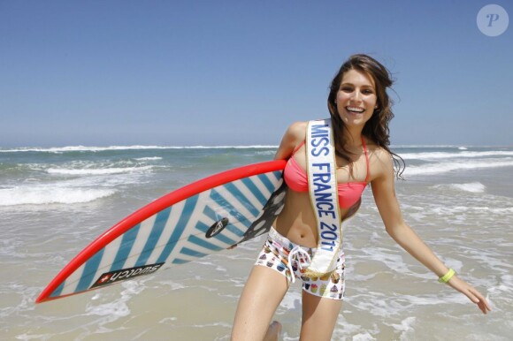 Laury Thilleman prend la pose avec sa planche de surf pour l'élection de Miss Univers