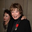 Shirley MacLaine décorée en grande pompe devant des icônes du cinéma