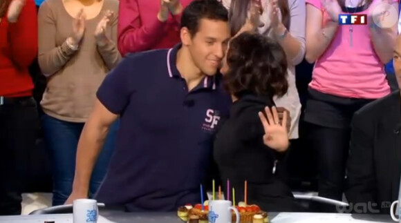 Florence Foresti embrasse Julien qui prend la pose au mois de novembre sur le calendrier des Dieux du Stade sur le plateau des Enfants de la télé sur TF1 le samedi 26 novembre 2011 - émission enregistrée le 7 novembre 2011