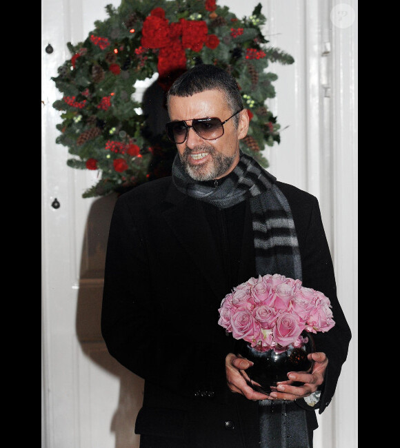 George Michael et un bouquet de fleurs s'exprime sur son état de santé, à Londres, le 23 décembre 2011