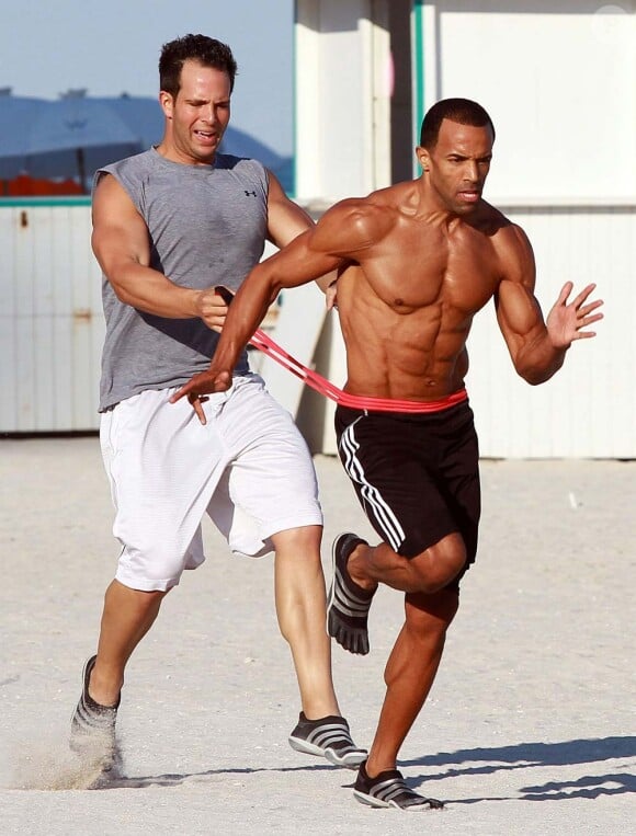 Craig David s'entraîne, en compagnie de son coach, sur une plage de Miami, le 7 janvier 2012.