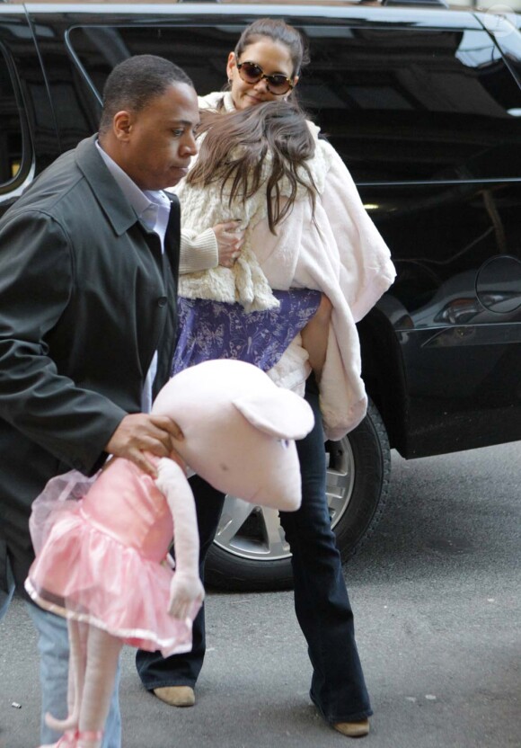 Suri dans les bras de Katie Holmes, la grosse souris dans ceux du garde du corps à New York, le vendredi 13 janvier 2011.