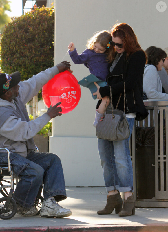 Alyson Hannigan et sa fille Satyana viennent en aide à un homme défavorisé à Los Angeles, le 17 janvier 2012.